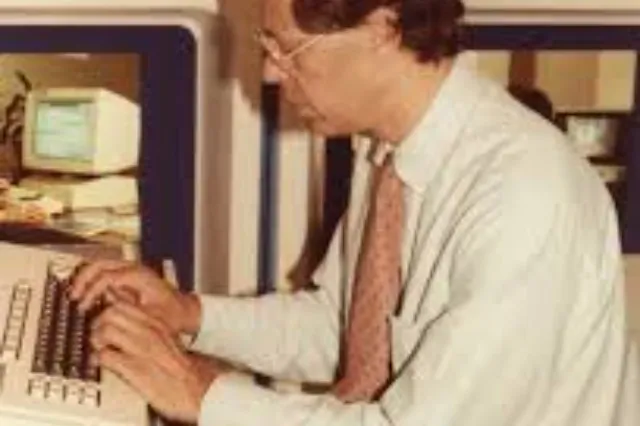A young man seated at a computer terminal, likely in a university research lab