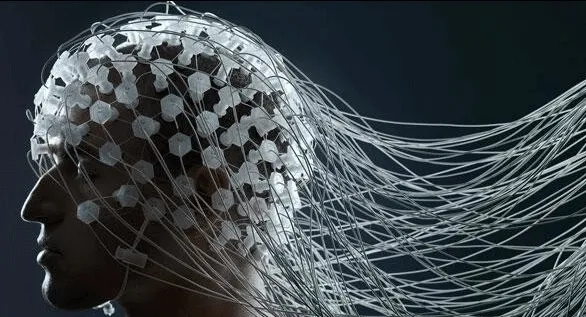 Electrode array alongside a screen displaying decoded handwritten letters from neural signals