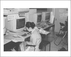 Researchers or officials gathered around early computer hardware at a formal launch event