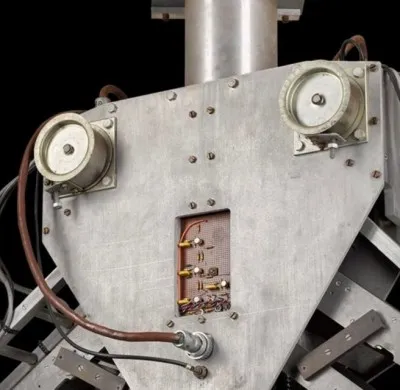 Robotic arm positioned above a workbench scattered with simple geometric objects