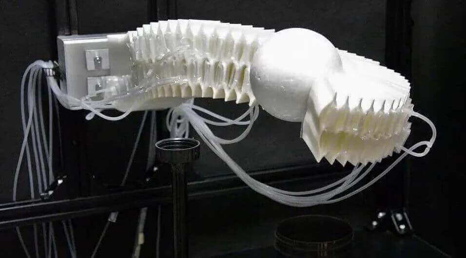 A soft-bodied four-legged robot on a flat surface, with no visible electronic components