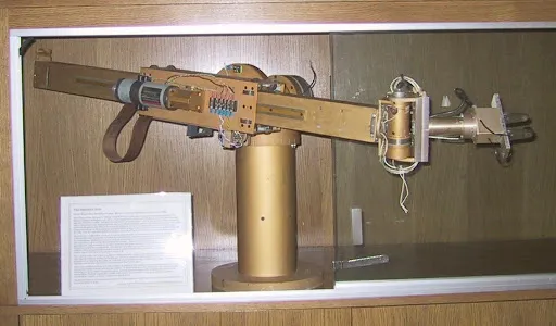 Engineer operating a multi-jointed robotic arm connected to a computer terminal