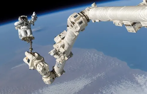 Canadarm2 extending from the exterior of the International Space Station against the backdrop of Earth or space