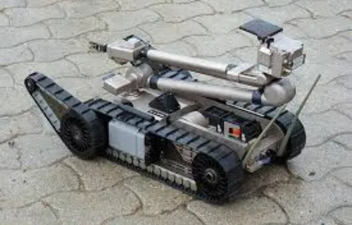 A tracked ground robot with a camera mast operating in rubble and debris